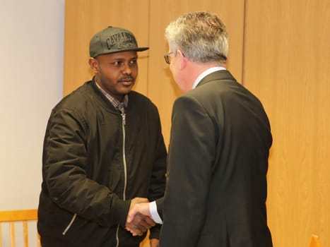 Federal Interior Minister Thomas de Maizière (CDU) welcomes refugee Hashem Gassin from Sudan to the Magdeburg City Mission on 21.02.2017