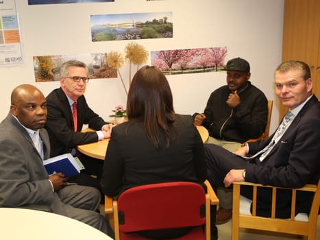Federal Interior Minister Thomas de Maizière (CDU) (2nd from left) with refugee Hashem Gassin (2nd right) from Sudan in Magdeburg city mission on 21.2.17