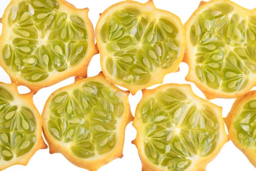 Several slices of kiwano fruit on white.