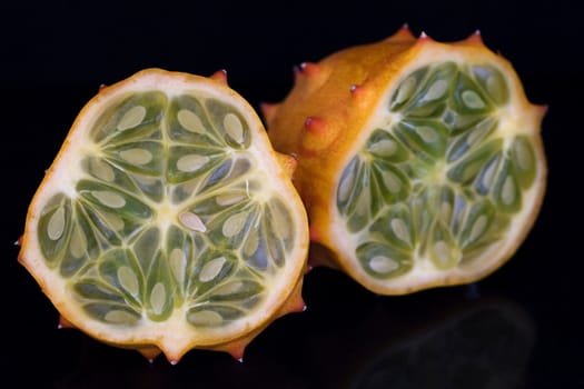 Kiwano fruit cut in half on black background