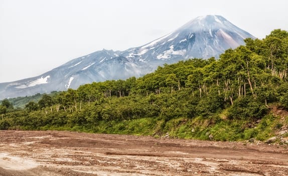 Mountains and volcanoes. Beautiful landscape of Kamchatka Peninsula: summer panoramic view of Mountain Range Vachkazhets, mountain lake and clouds in blue sky on sunny day. Eurasia, Russian Far East, Kamchatka Region.