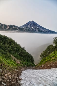 Mountains and volcanoes. Beautiful landscape of Kamchatka Peninsula: summer panoramic view of Mountain Range Vachkazhets, mountain lake and clouds in blue sky on sunny day. Eurasia, Russian Far East, Kamchatka Region.