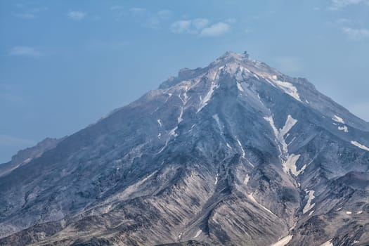 Mountains and volcanoes. Beautiful landscape of Kamchatka Peninsula: summer panoramic view of Mountain Range Vachkazhets, mountain lake and clouds in blue sky on sunny day. Eurasia, Russian Far East, Kamchatka Region.