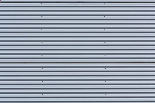 Silver-colored metal wall corrugated sheet metal as background..
