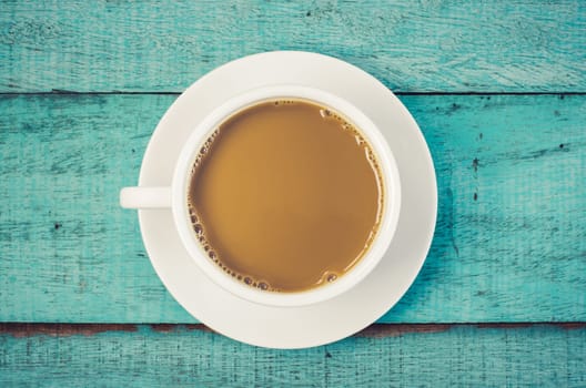 Top view cup of coffee on blue wooden table. Vintage filter.