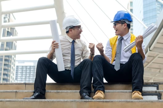 Success business concept. Two asian architects keeping hands up with happy moment.