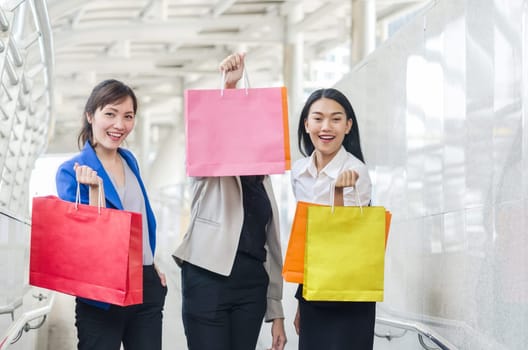Group of shopping asia women holding up shopping bags. Happiness, consumerism, sale concept.