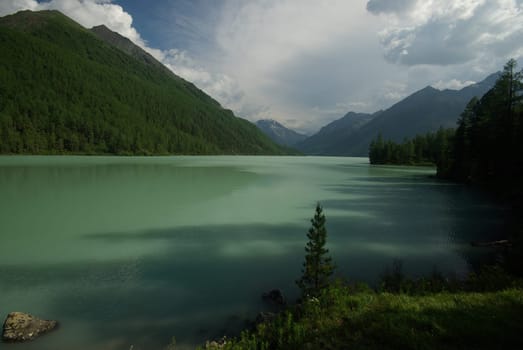 Beautiful mountain landscape near the lake. Mountain Lake. Kind of mountainous terrain and the water in the valley.