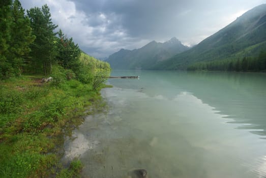 Beautiful mountain landscape near the lake. Mountain Lake. Kind of mountainous terrain and the water in the valley.
