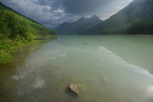 Beautiful mountain landscape near the lake. Mountain Lake. Kind of mountainous terrain and the water in the valley.