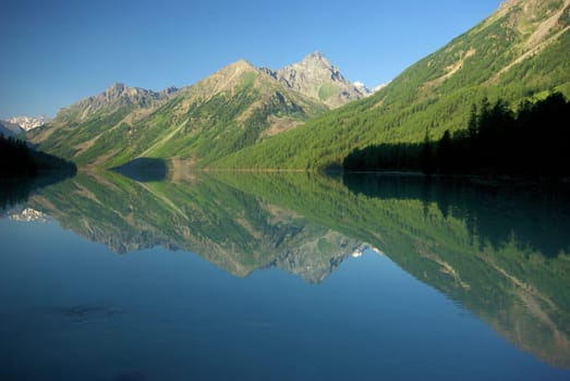 Beautiful mountain landscape near the lake. Mountain Lake. Kind of mountainous terrain and the water in the valley.
