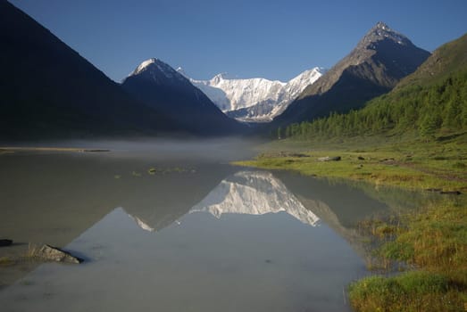 Beautiful mountain landscape near the lake. Mountain Lake. Kind of mountainous terrain and the water in the valley.