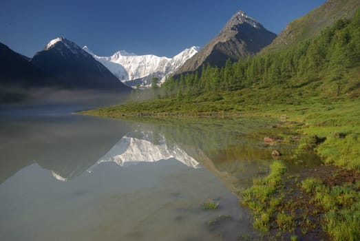 Beautiful mountain landscape near the lake. Mountain Lake. Kind of mountainous terrain and the water in the valley.