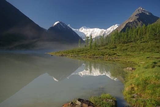 Beautiful mountain landscape near the lake. Mountain Lake. Kind of mountainous terrain and the water in the valley.