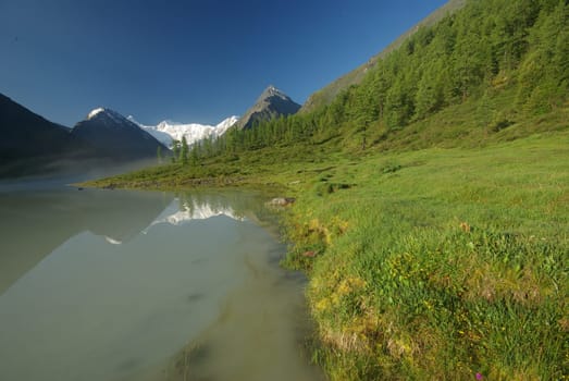 Beautiful mountain landscape near the lake. Mountain Lake. Kind of mountainous terrain and the water in the valley.
