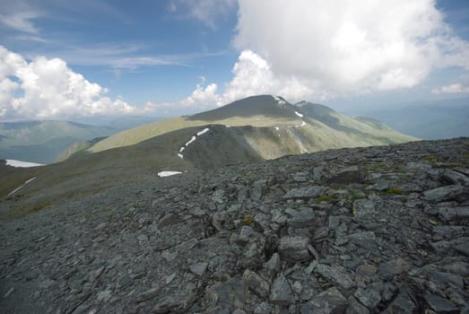 Mountain landscape. Highlands, the mountain peaks, gorges and valleys. The stones on the slopes.