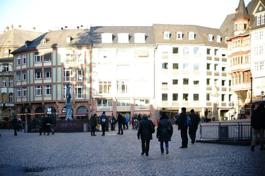 Frankfurt,Germany - January 05,2017: Visitors and tourists visit the Römerberg with historic buildings and the Fountain of Justice on January 5,2017 in Frankfurt.
