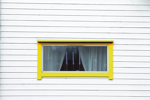 white wood wall yellow window curtain three candles