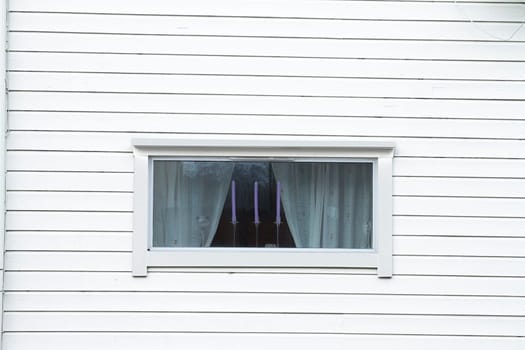 white wood wall white window curtain three candles