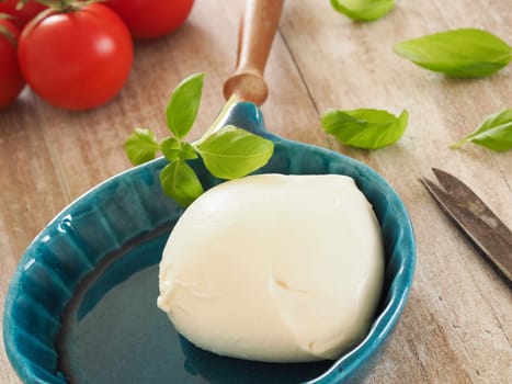 Fresh organic mozzarella with basil and tomatoes in a kitchen