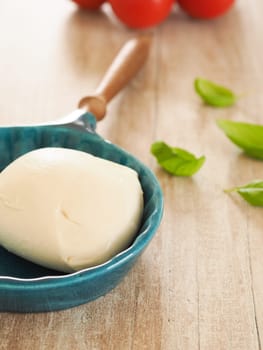 Fresh organic mozzarella with basil and tomatoes in a kitchen