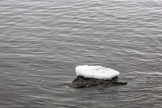 Ice on Top of Rock in Water.