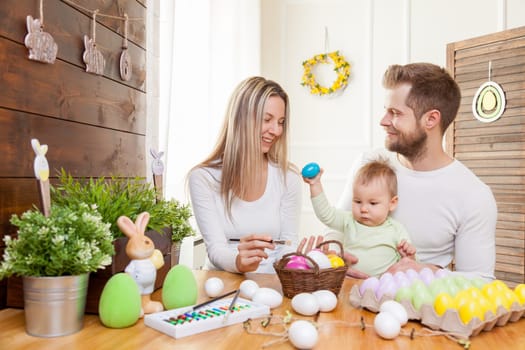 Easter concept. Happy and loving mother and father preparing home decoration with their child for Easter holidays