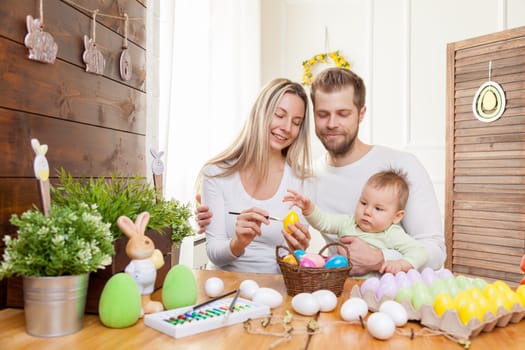 Easter concept. Happy and loving mother and father preparing home decoration with their child for Easter holidays