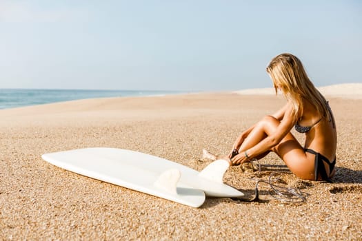 Beauitful young surfer girl running to the waves with her surfboard