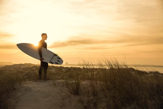 A surfer with his surfboard at the beach