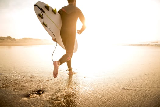 A surfer with his surfboard at the beach