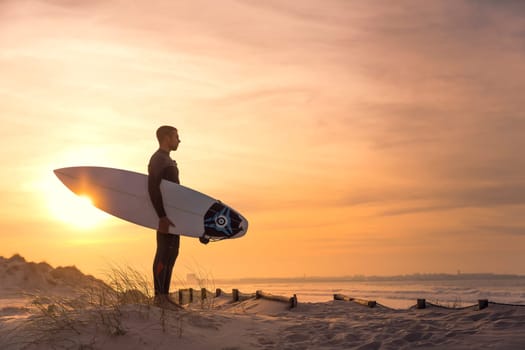 A surfer with his surfboard at the beach