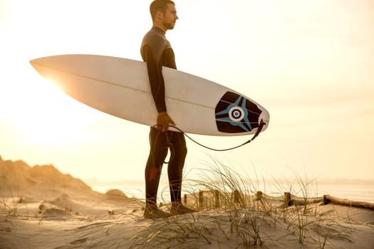 A surfer with his surfboard at the beach