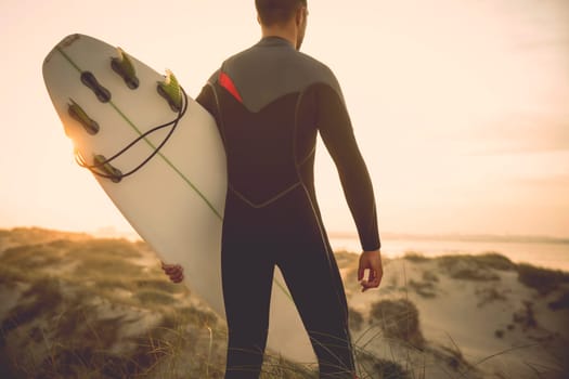A surfer with his surfboard at the beach