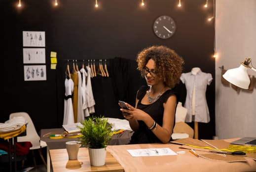 A young fashion designer on her atelier making a phone call