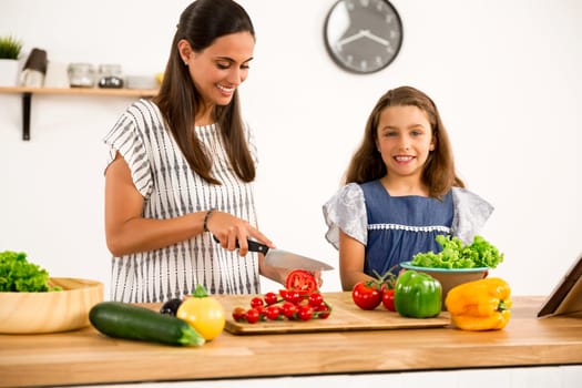 Shot of a mother and daughter having fun in the kitchen