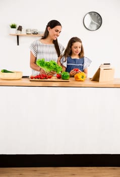 Shot of a mother and daughter having fun in the kitchen