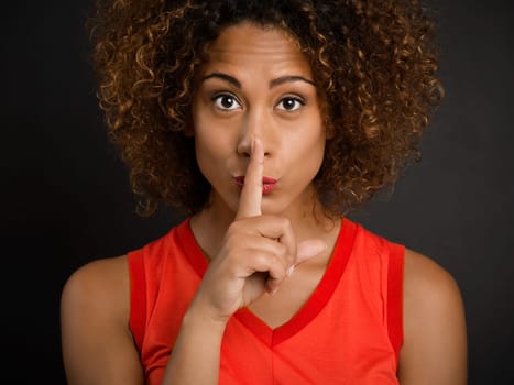 Portrait of a beautiful African American woman asking for silence