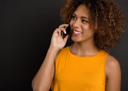 Beautiful African American woman making a phone call and laughing