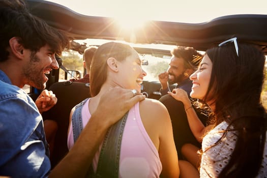 Five friends travelling together on a road trip in a car