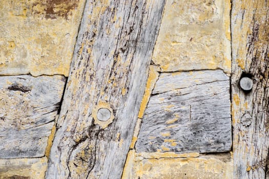 Detail of Old cracked oak timber in a timber-framed building. Oak wood structure with wattle and daub infill. Painted with yellow whitewash