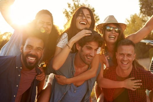 Three couples having fun piggybacking at sundown