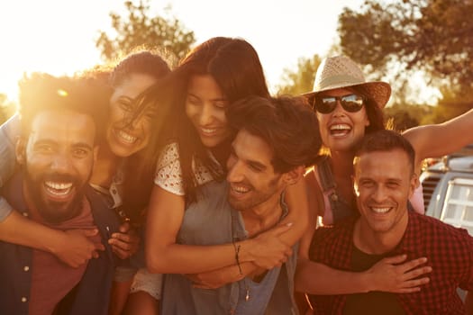 Three couples having fun piggybacking at sundown