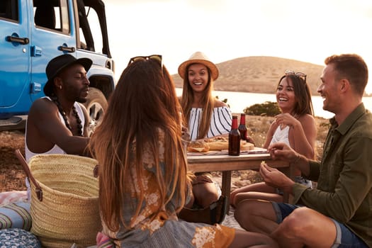 Group Of Friends Enjoying Picnic On Cliffs By Sea