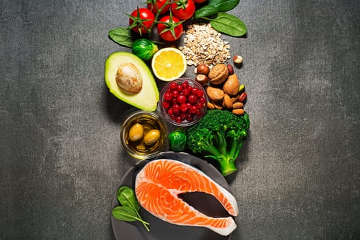 Selection of healthy food. Raw steak of salmon with fresh ingredients on gray background.