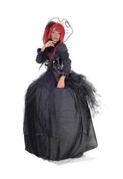 A full body image of an African American young woman in a black .Victorian dress and red hair standing isolated for white background..