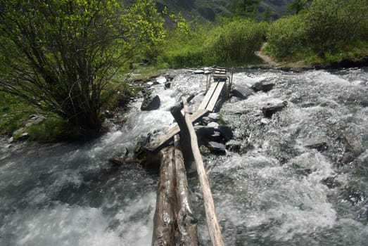 The mountain river in the mountains. Current through the gorge the river. Stones and rocky land near the river. Beautiful mountain landscape.