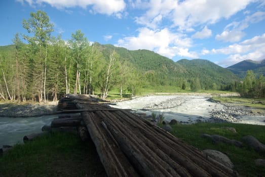 The mountain river in the mountains. Current through the gorge the river. Stones and rocky land near the river. Beautiful mountain landscape.