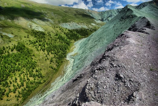 The mountain river in the mountains. Current through the gorge the river. Stones and rocky land near the river. Beautiful mountain landscape.