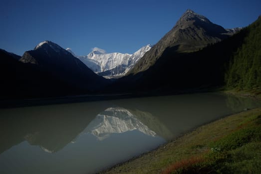The mountain river in the mountains. Current through the gorge the river. Stones and rocky land near the river. Beautiful mountain landscape.